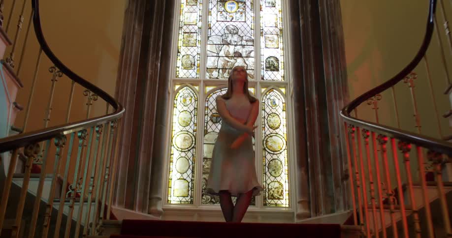 A woman dances at the top of some stairs
