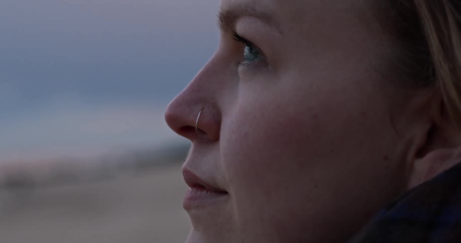 A woman with a nose ring staring off into the distance