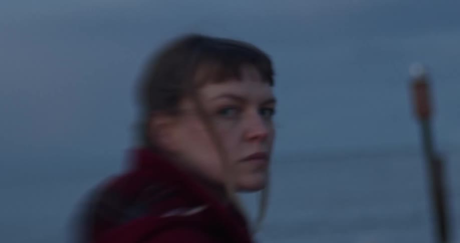 Out of focus shot of woman looking at the camera at the beach
