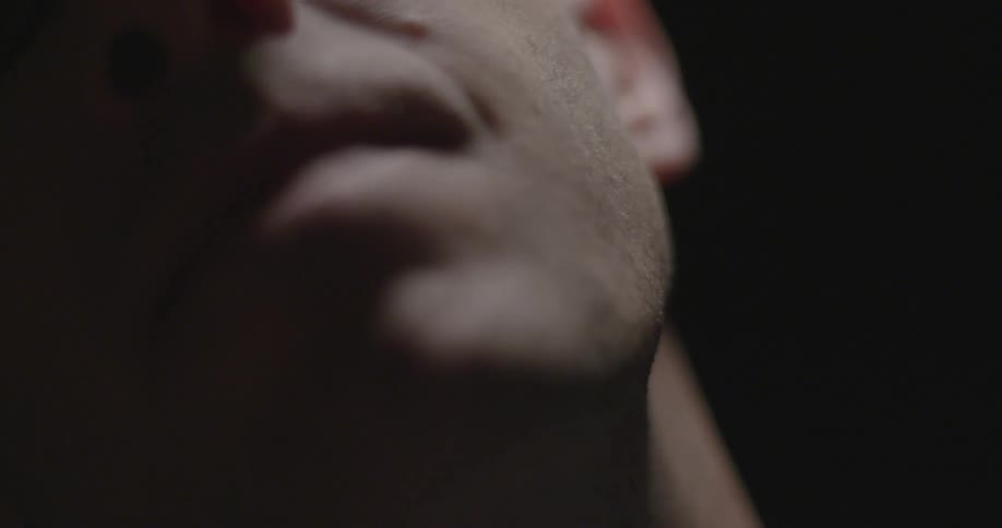 A man is talking in a dark area
