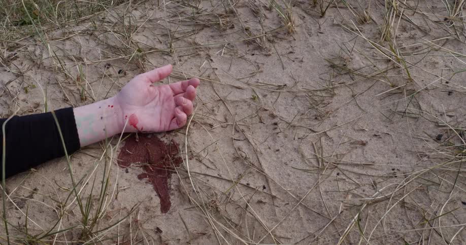 A white womans hand bleeds on to the ground