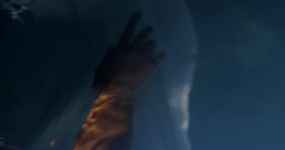 Woman wearing white dress floats underwater
