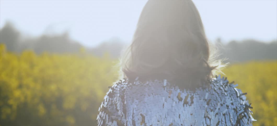 Woman slowly walks on a flower field