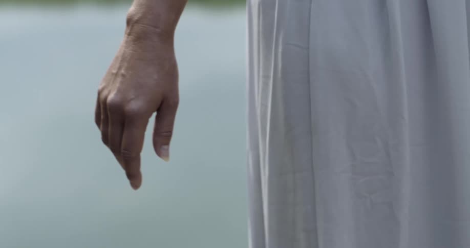A woman in a dress moves her arm back and forth