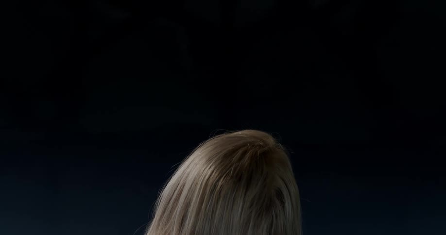 The back of a persons head with a dark blue background