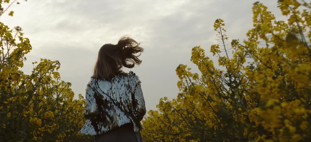A woman runs down a path lined with flowers