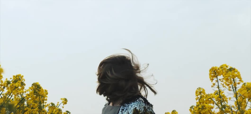 A woman is running through a flower meadow