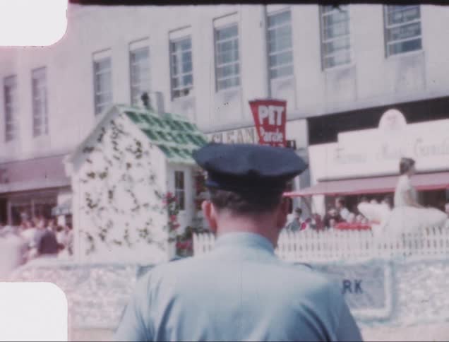 A police officer watches a float go by during a small town parade