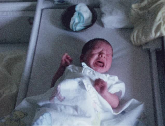 Small baby cries waving its arms and kicking