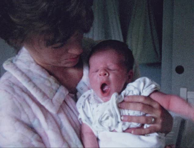 Mother holding a new born baby at home