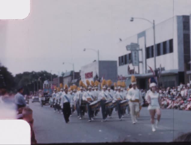 A band marches in a parade through the main street of a small town