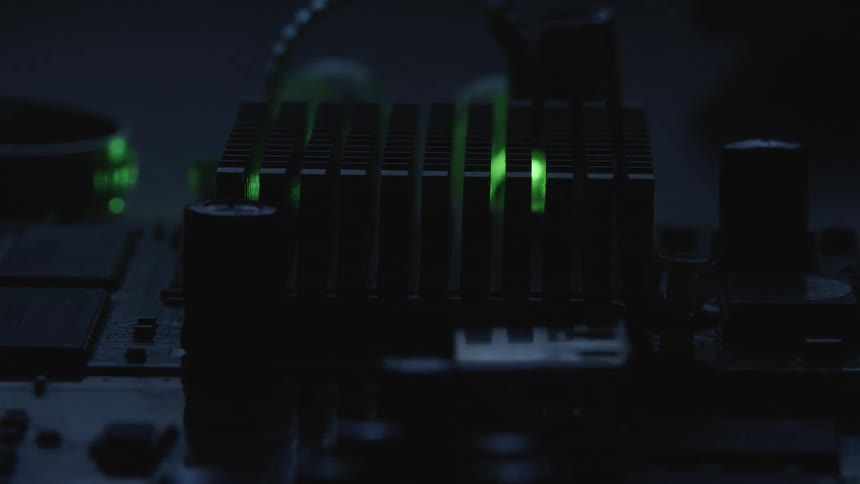 Lights on circuitry flash from green to red to blue as the lights in the room flash on and off