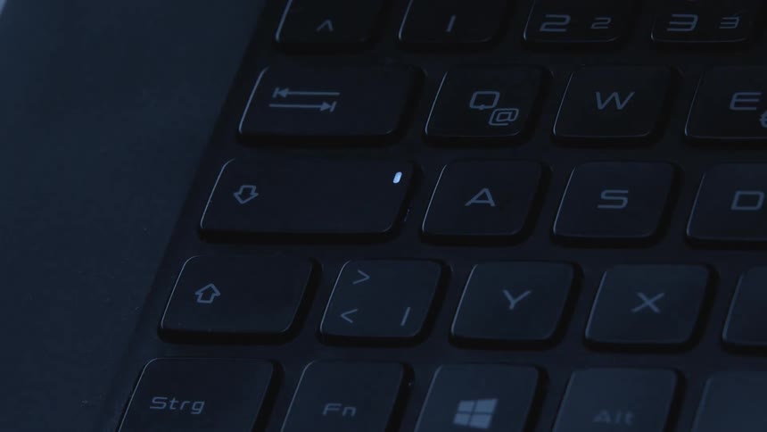 Close up of laptop keyboard on a dimly lit room
