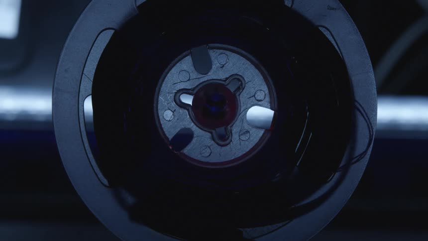 A roll of black wiring lights up with a bluish tinge