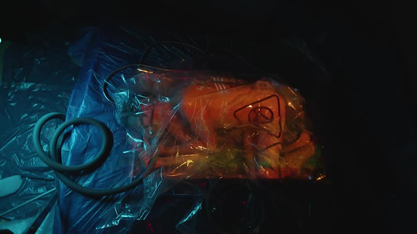 Lights and symbol flash on a plastic bag containing a white persons body