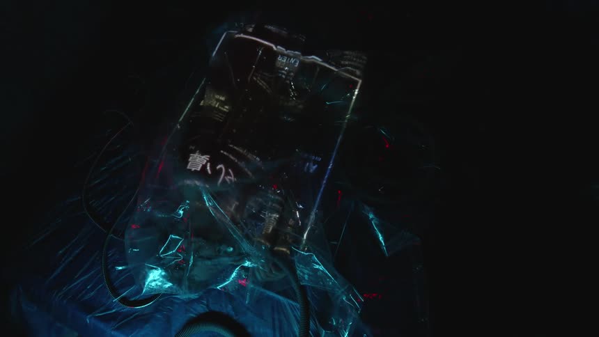 A white person enclosed in a plastic bag as symbols and lights flash on it