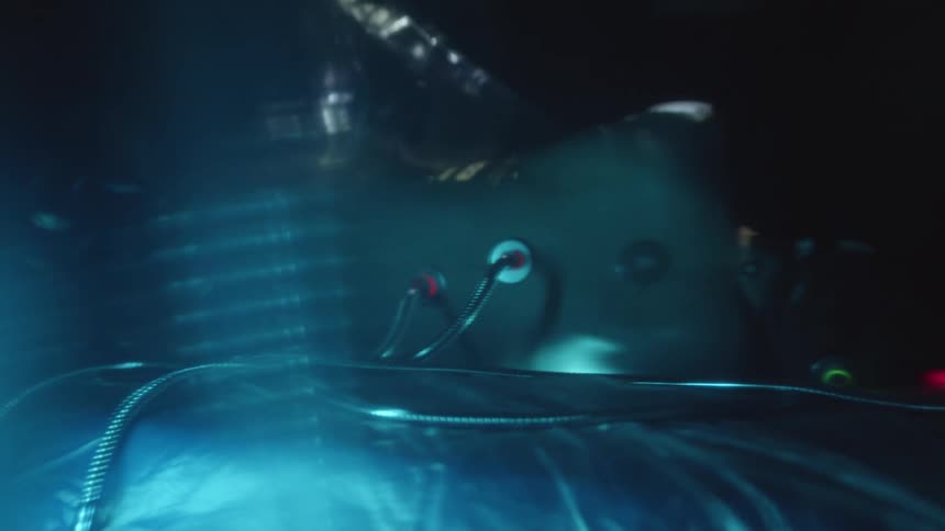 A plastic wrap is removed from a body attached to cables