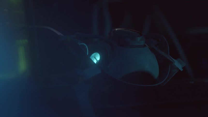 A face mask with a light and straps sits on a surface indoors