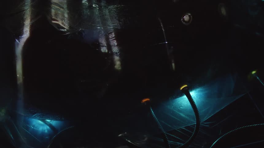 A body with cables plugged into has words and images projected onto it