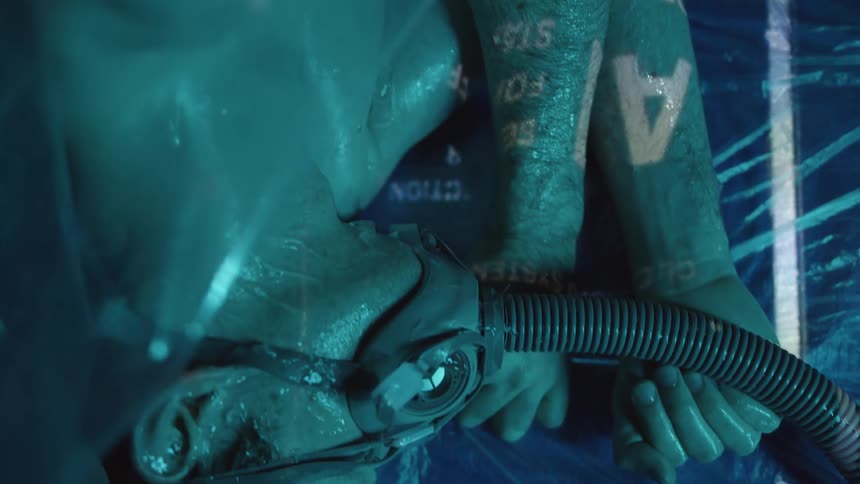 A teenager lying with a respirator