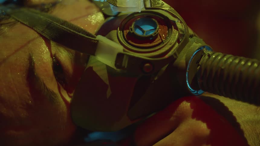 A man lies with a breathing tube on