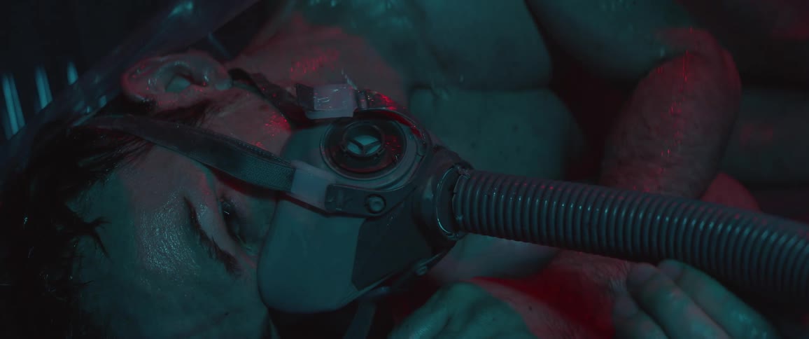 A badly injured man lies hooked up to a respirator