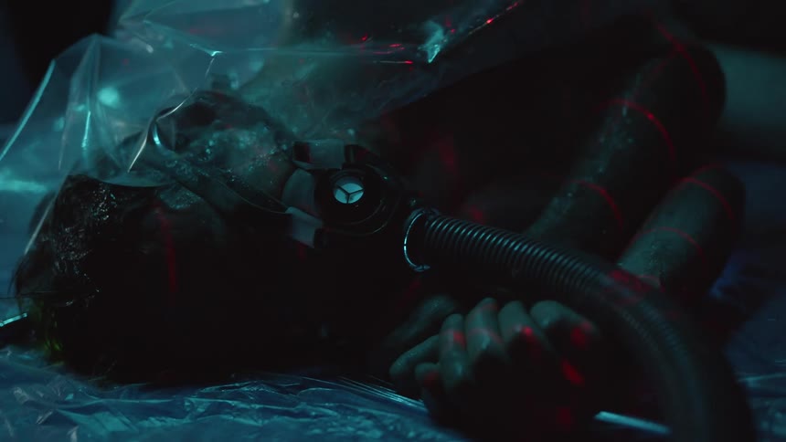 A person laying down with a mask on with a hose covered with plastic