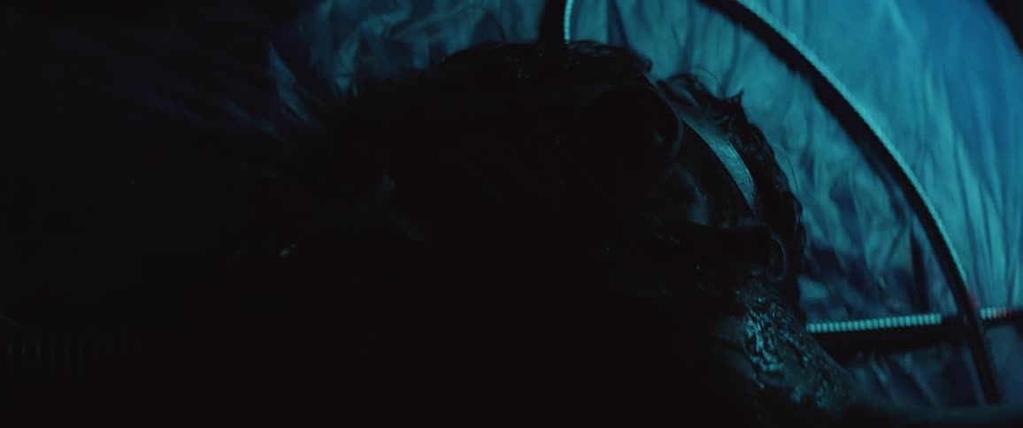 A person laying down with a mask and cables next to them