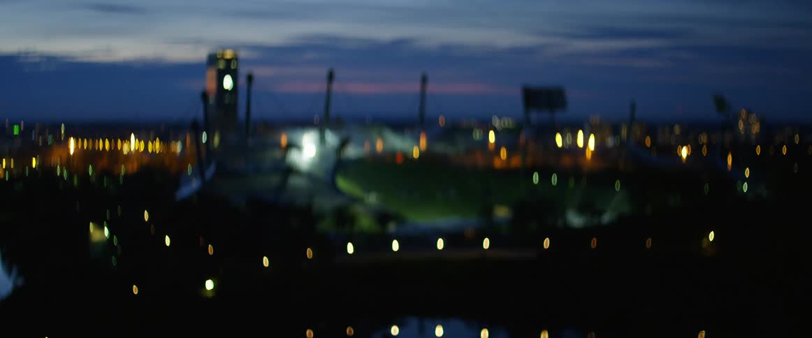 Soccer stadium in a city at sunset
