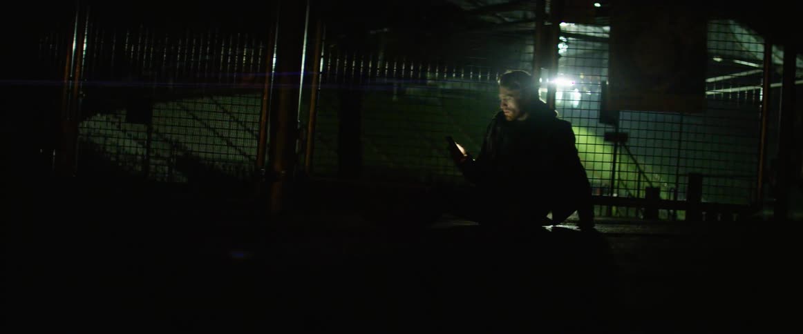Man sits and uses a smartphone at night
