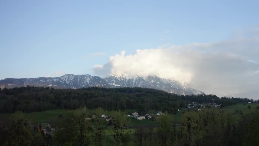 A small town with forest and mountains in the background