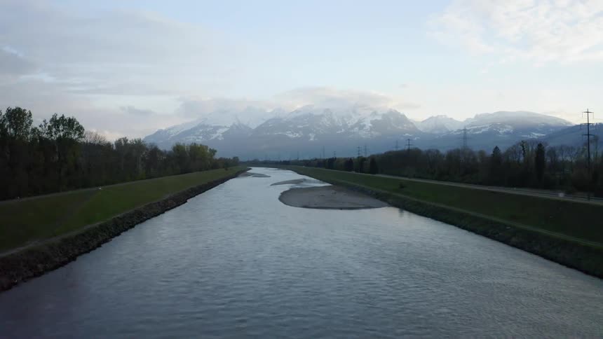 A river flows by next to a road and forested terrain