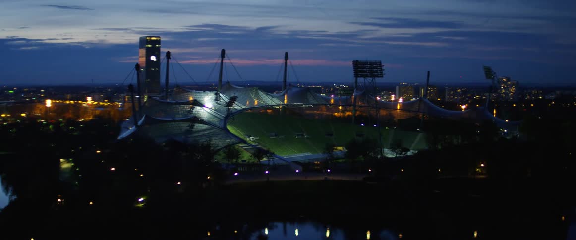 Traffic passes by an empty sports stadium at night