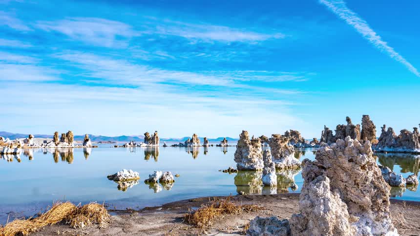 Rocks sit in the lake under a blue sky