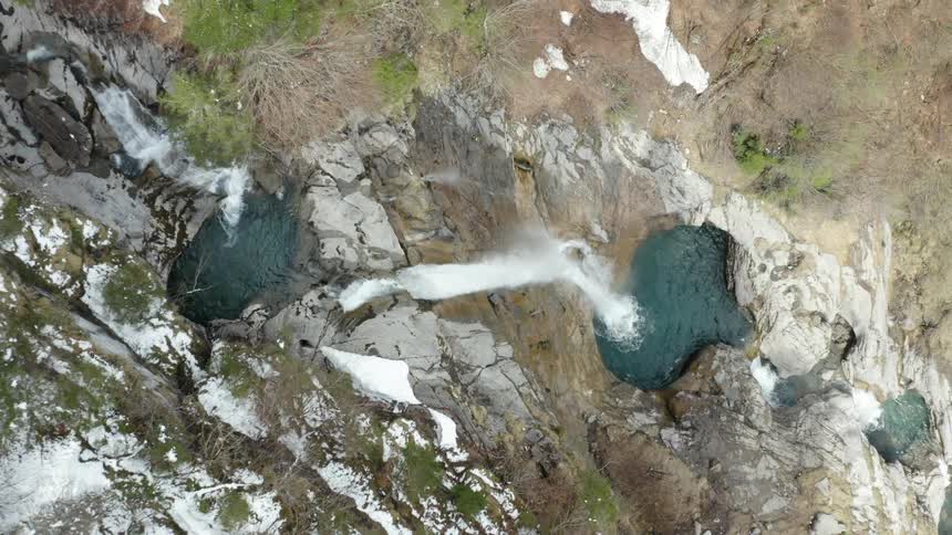An aerial view of a water fall is displayed