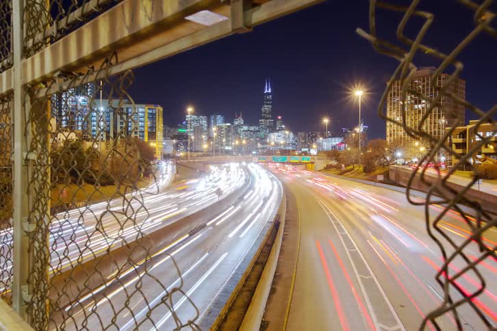 Timelapse of traffic over a highway near the city at night