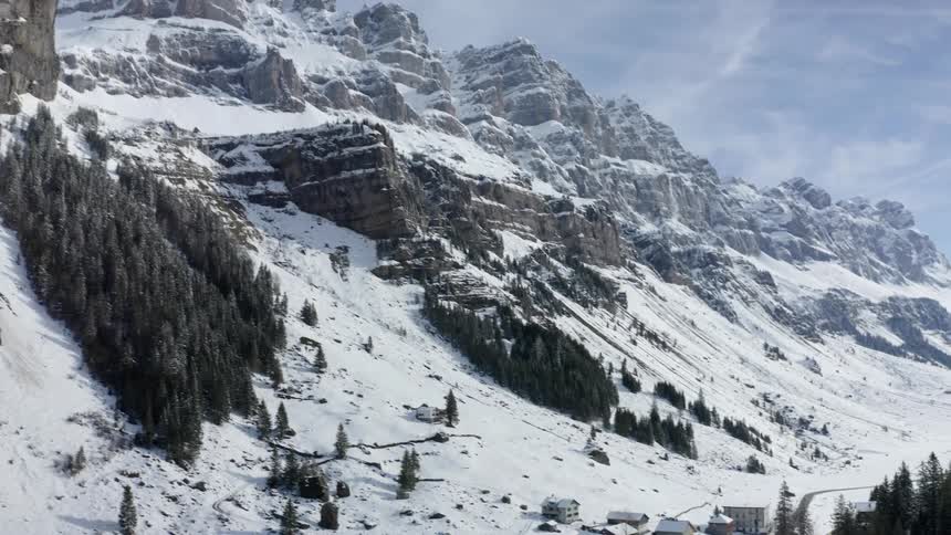 Buildings at the bottom of a snow covered mountain range
