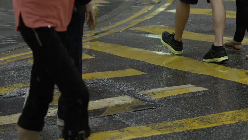 Pedestrians walk across symbols painted on street