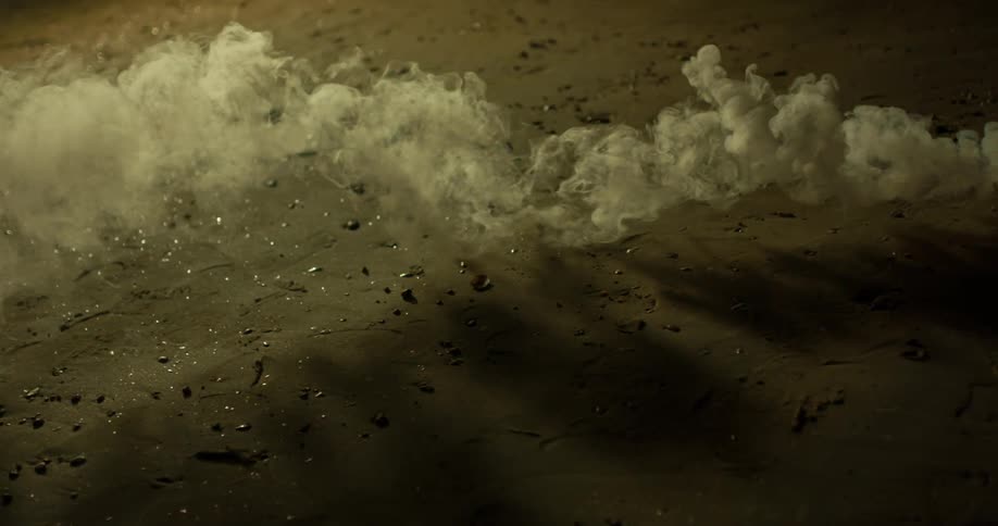 White smoke floats over the land at night