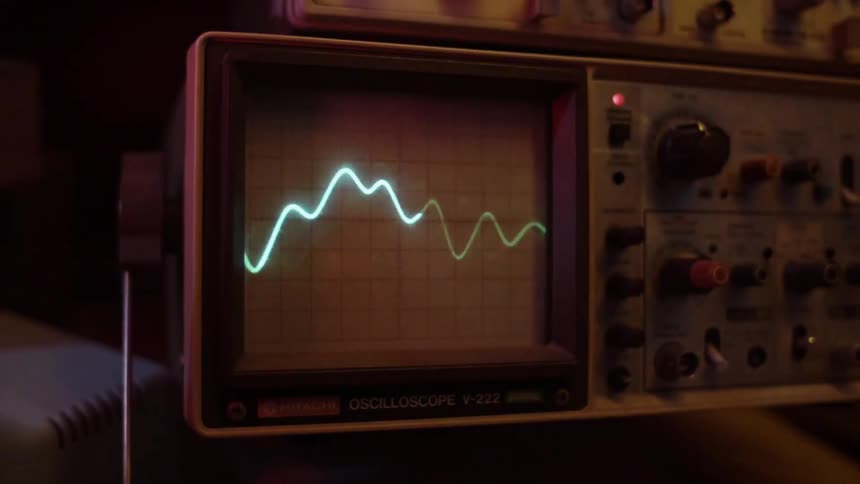 An oscilloscope shows a wavelength on a screen