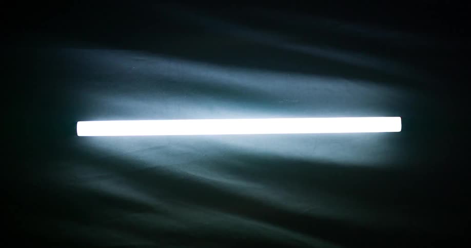Fabric ripples as a backdrop to a glowing and flickering fluorescent light