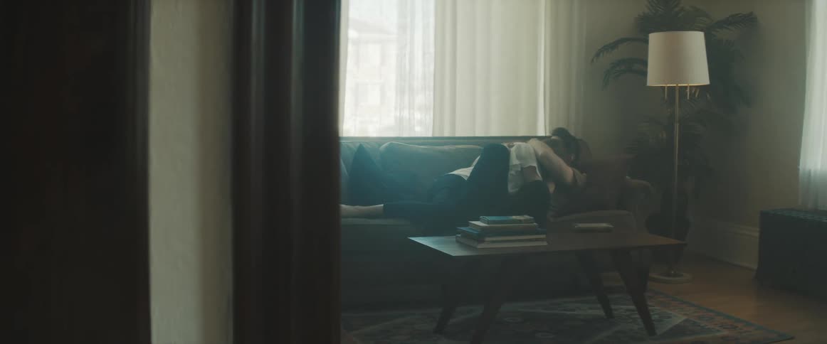 Woman kisses a man on the living room couch