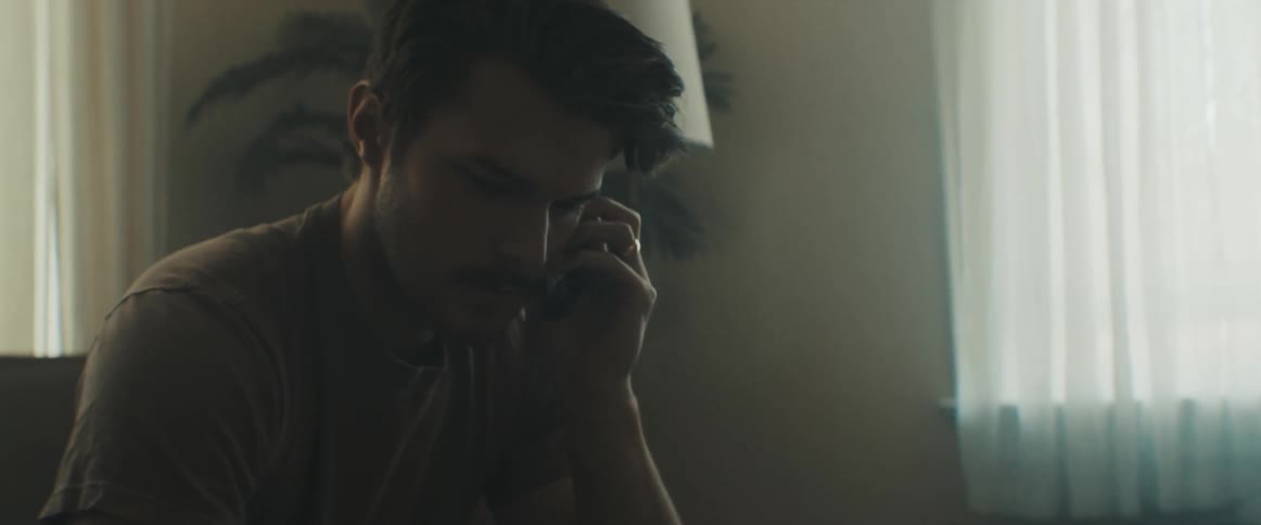 A man sits at home and talks on the phone