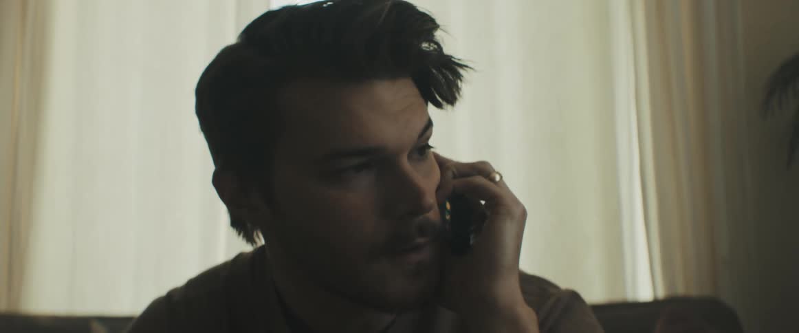 Man sitting on the sofa speaks on the phone in the living room