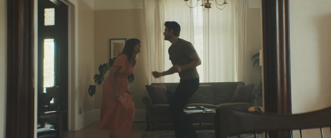 A man and woman dance around their living room together