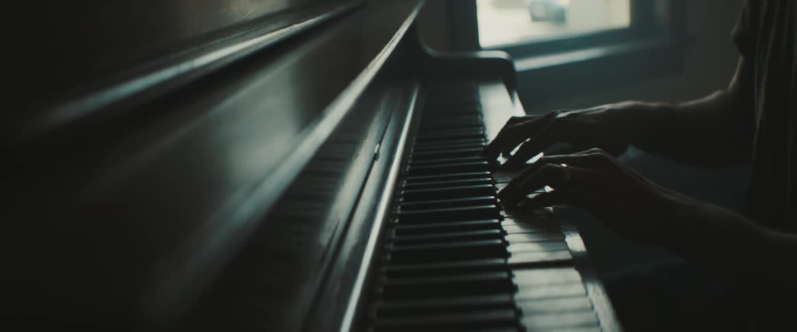 A man is playing piano indoors