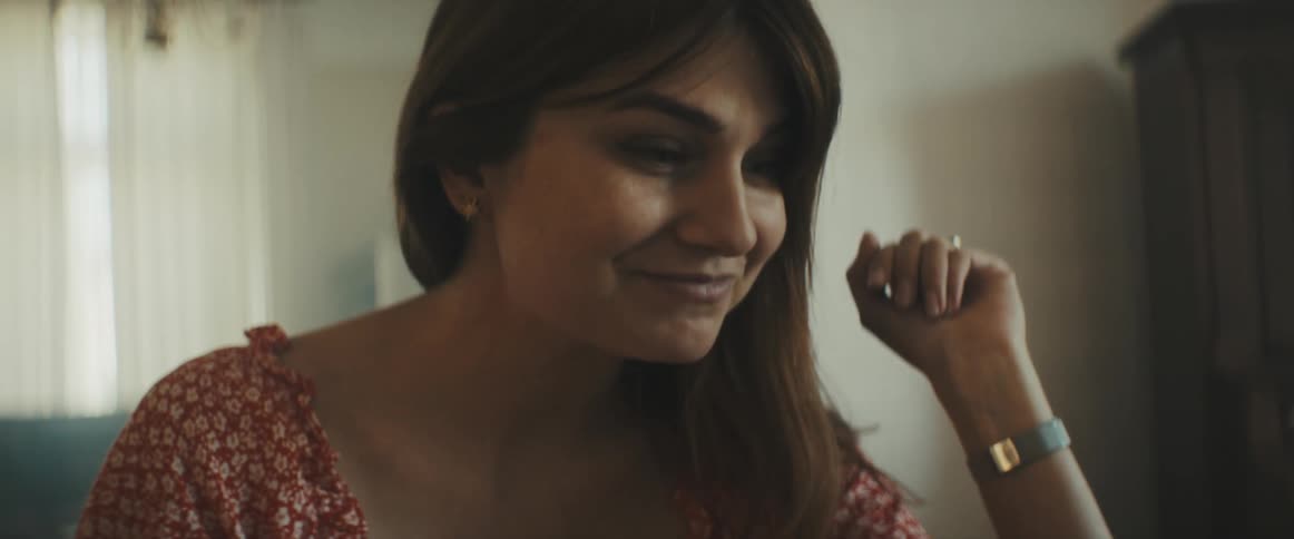 A woman in a room sitting down and smiling