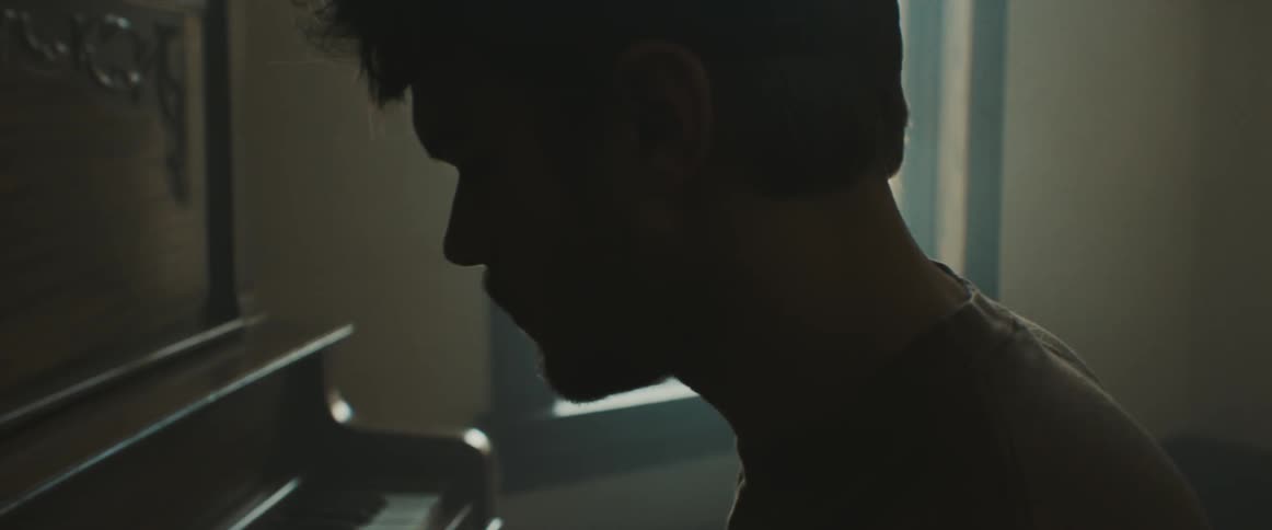 Male pianist plays the piano in the room