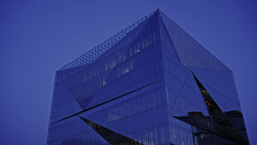 A high rise building covered in windows in a city