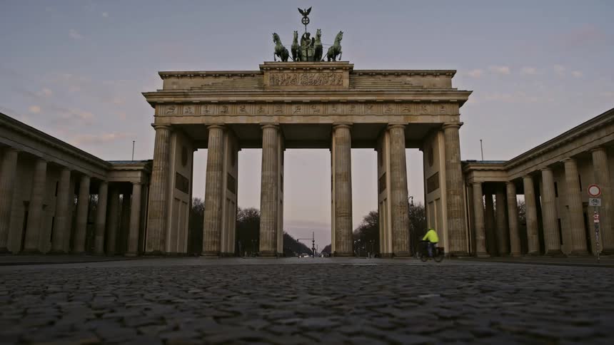 People riding bikes through the Brandenburg Gate